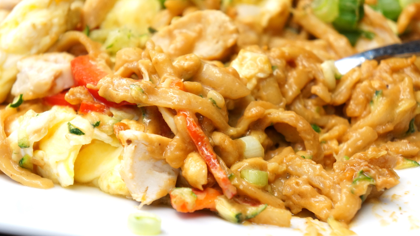 Close up of noodles with chicken and vegetables.